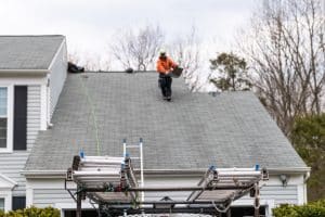 man walking on roof shingles