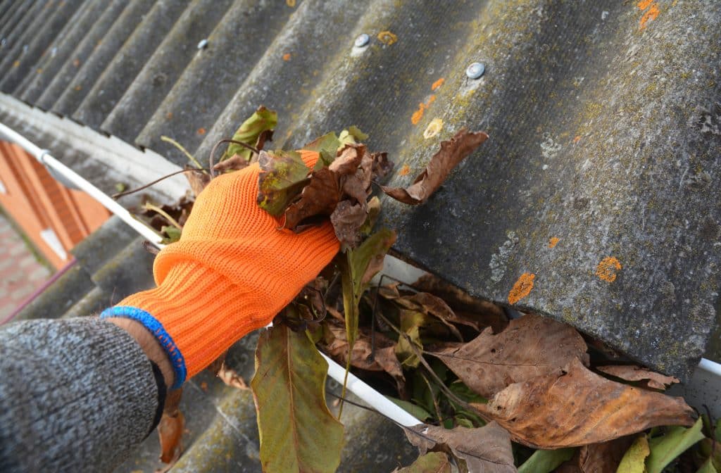 cleaning a blocked rain gutter
