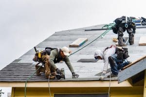 Crew Installing New Shingles on Roof